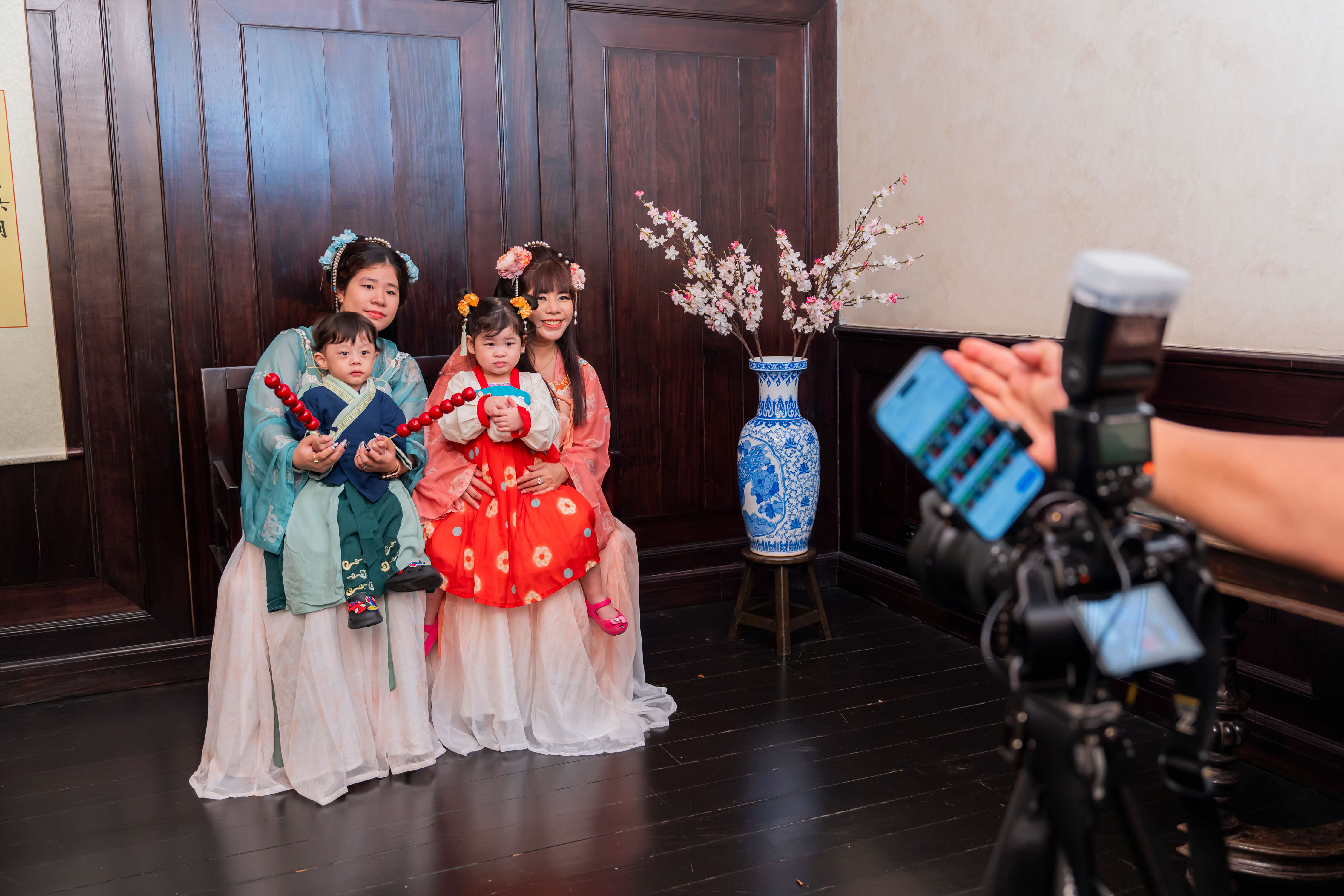 a group of women and children dressed in traditional hanfu posed for a photo